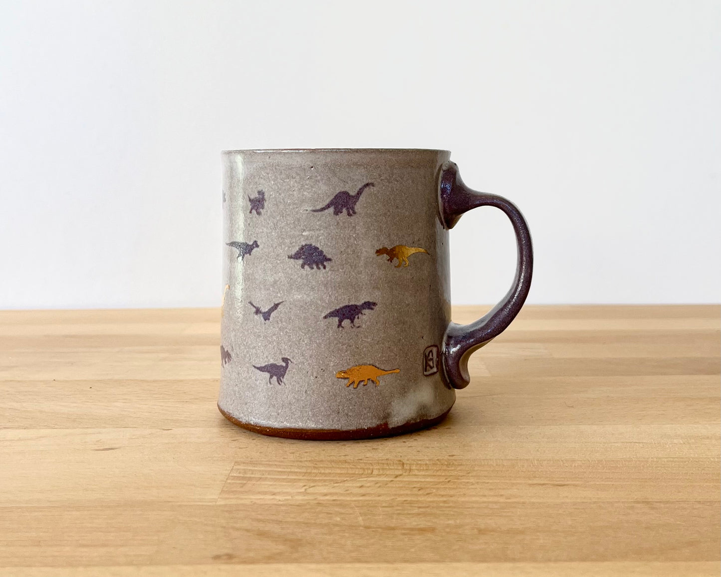 Mug with small purple and gold dinos
