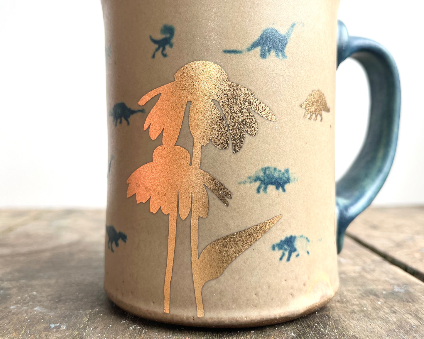 Mug with matte glaze and small blue and gold dinos