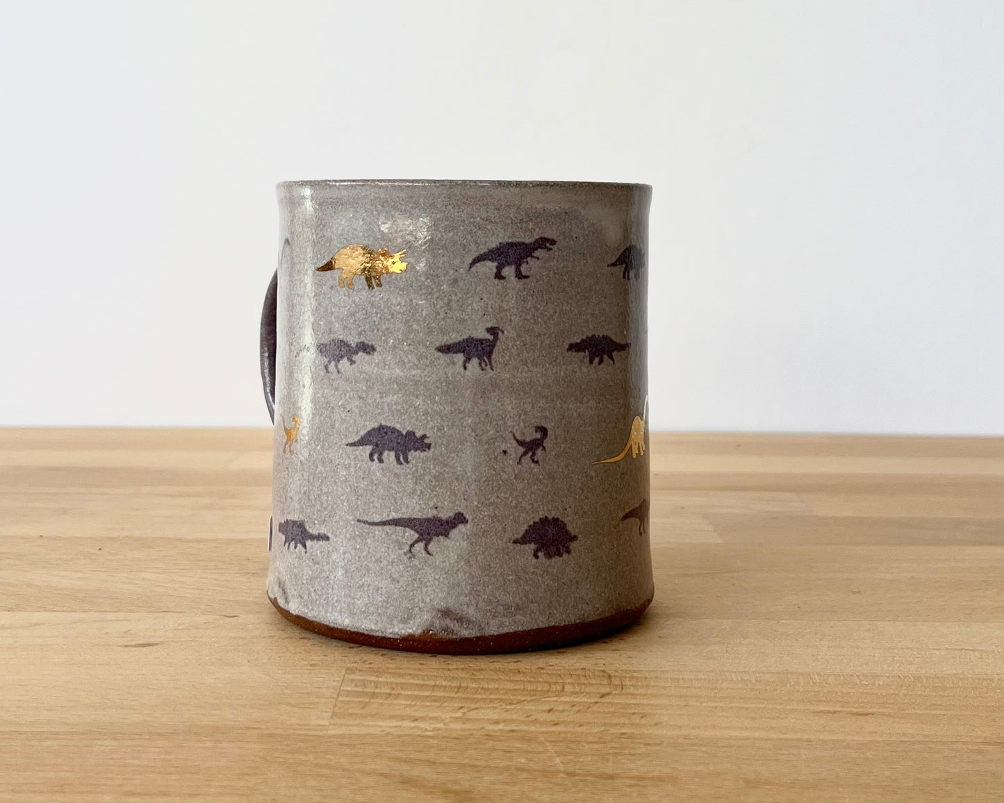 Mug with small purple and gold dinos