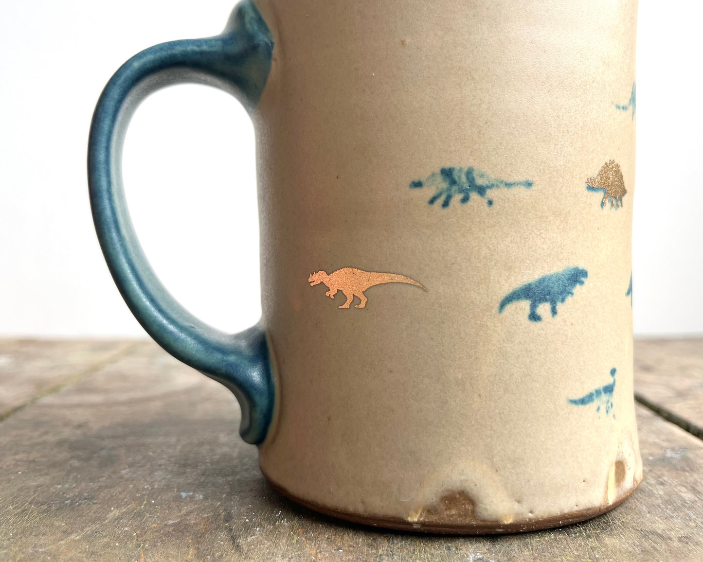 Mug with matte glaze and small blue and gold dinos