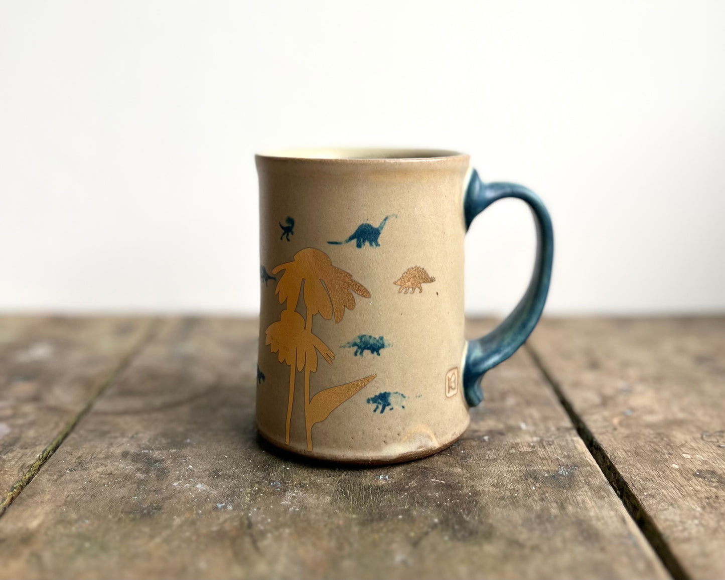 Mug with matte glaze and small blue and gold dinos
