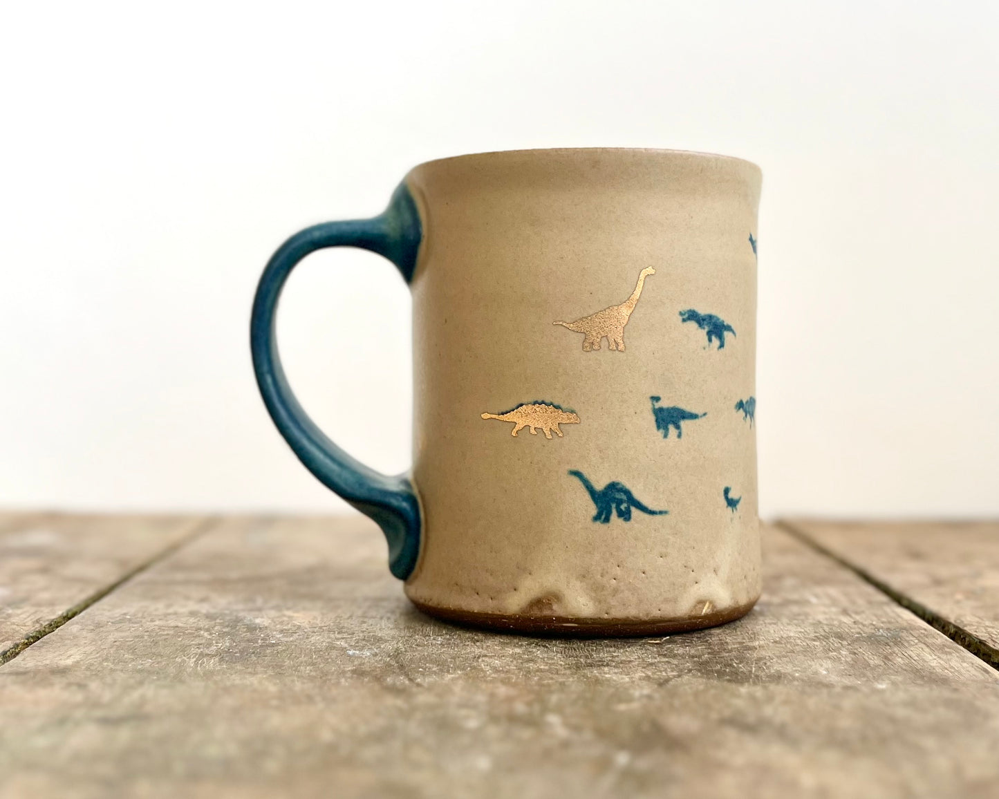 Mug with matte glaze and small blue and gold dinos