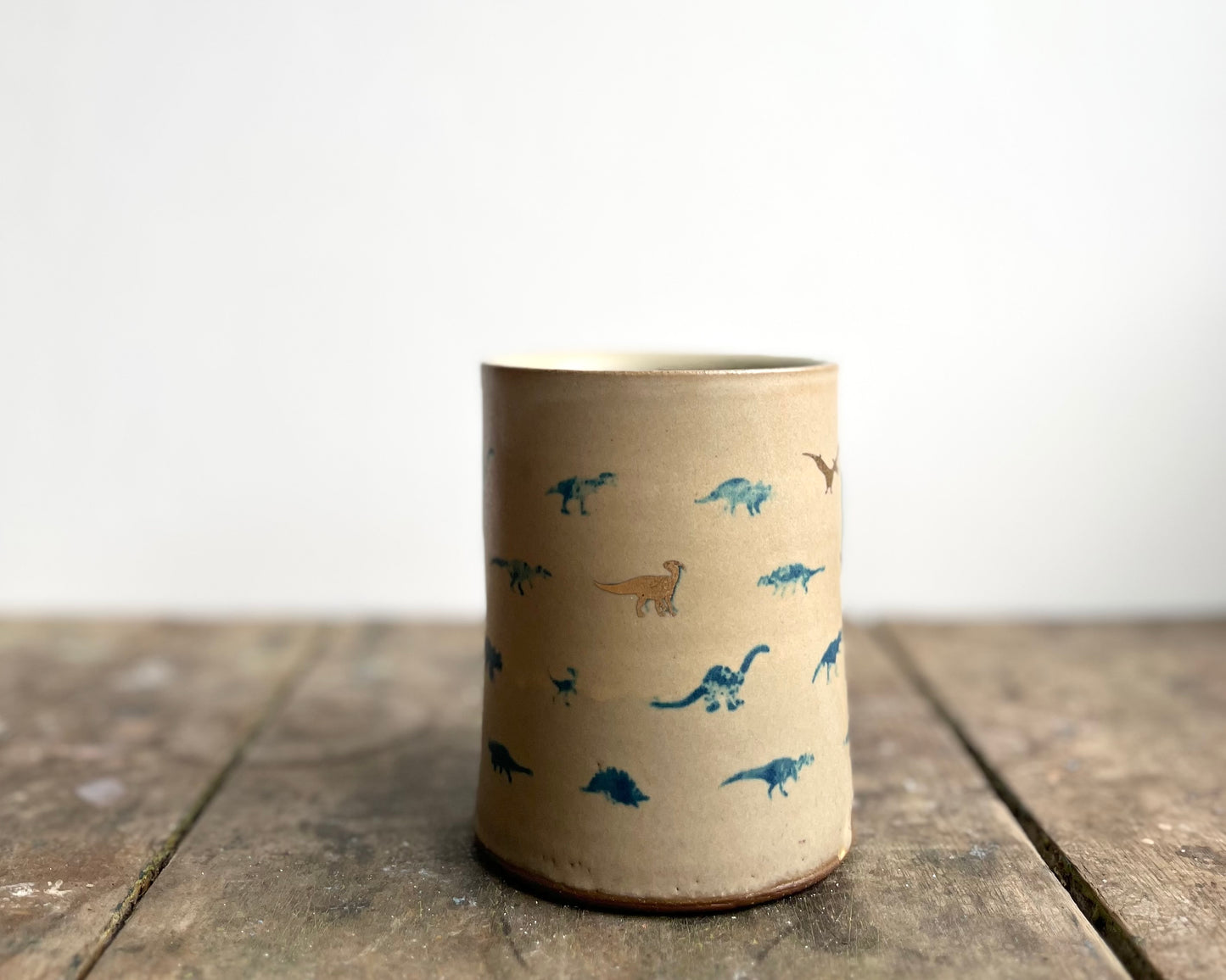 Mug with matte glaze and small blue and gold dinos