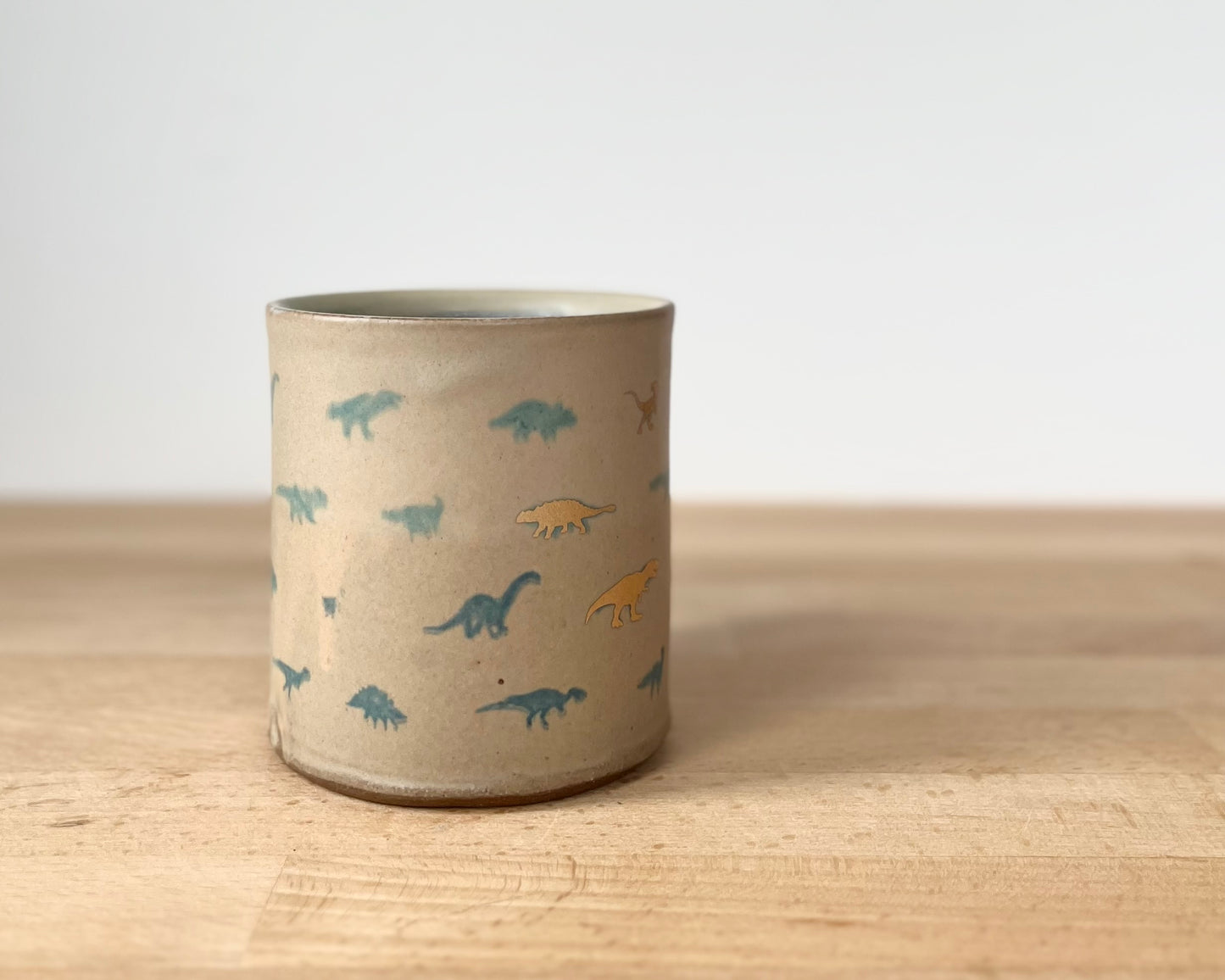 Mug with matte glaze and small blue and gold dinos