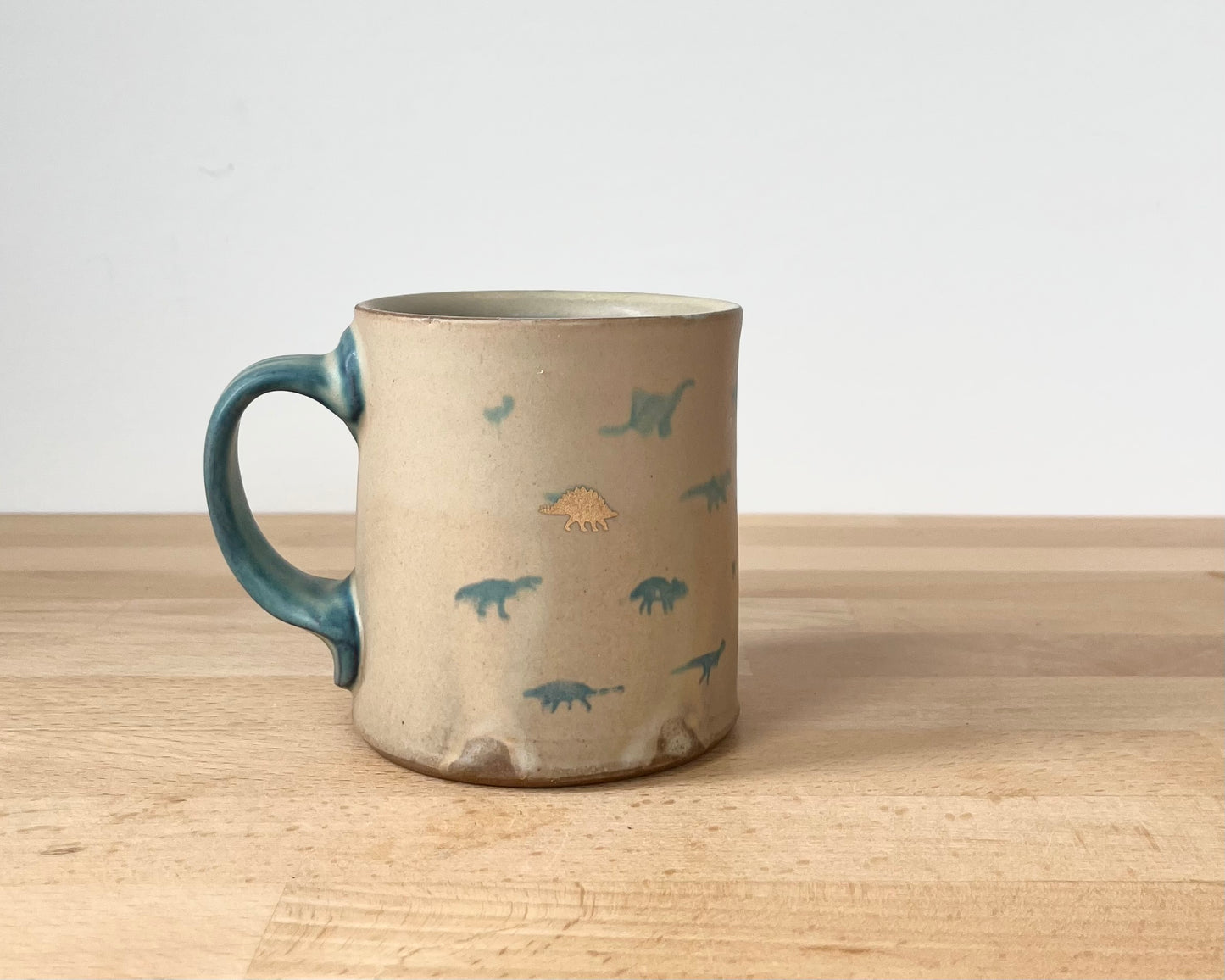 Mug with matte glaze and small blue and gold dinos