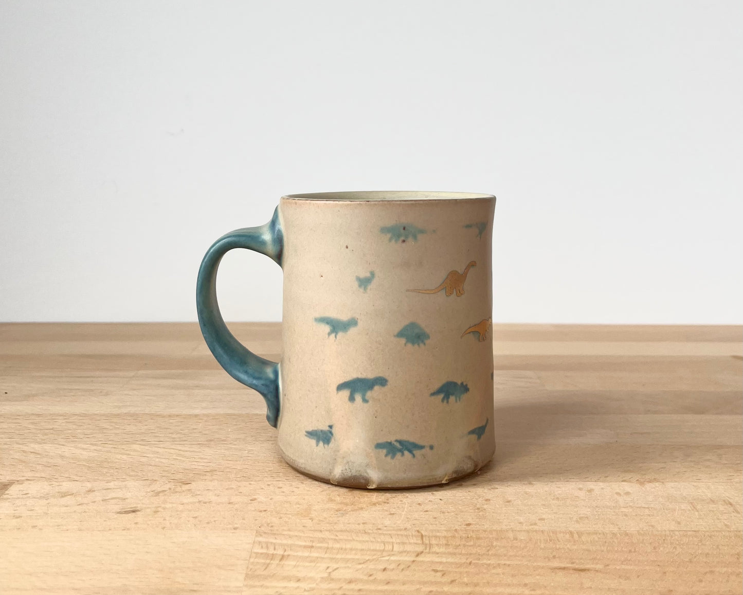 Mug with matte glaze and small blue and gold dinos