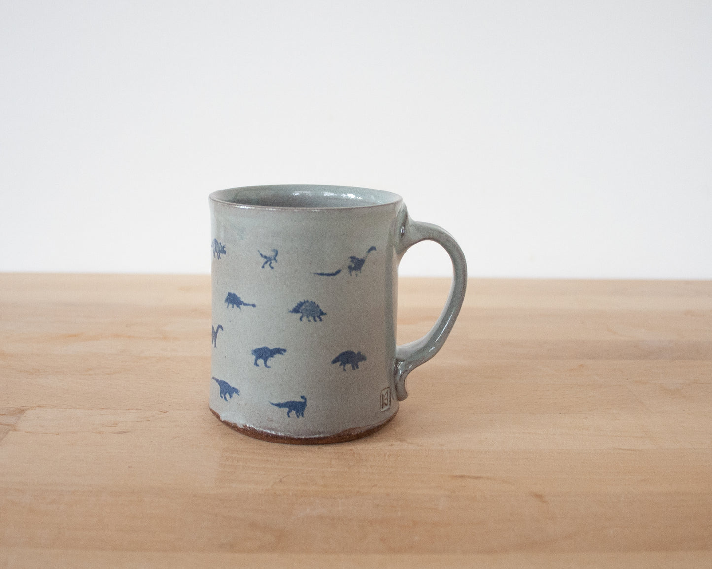 Gold Velociraptor Mug with small blue dinos