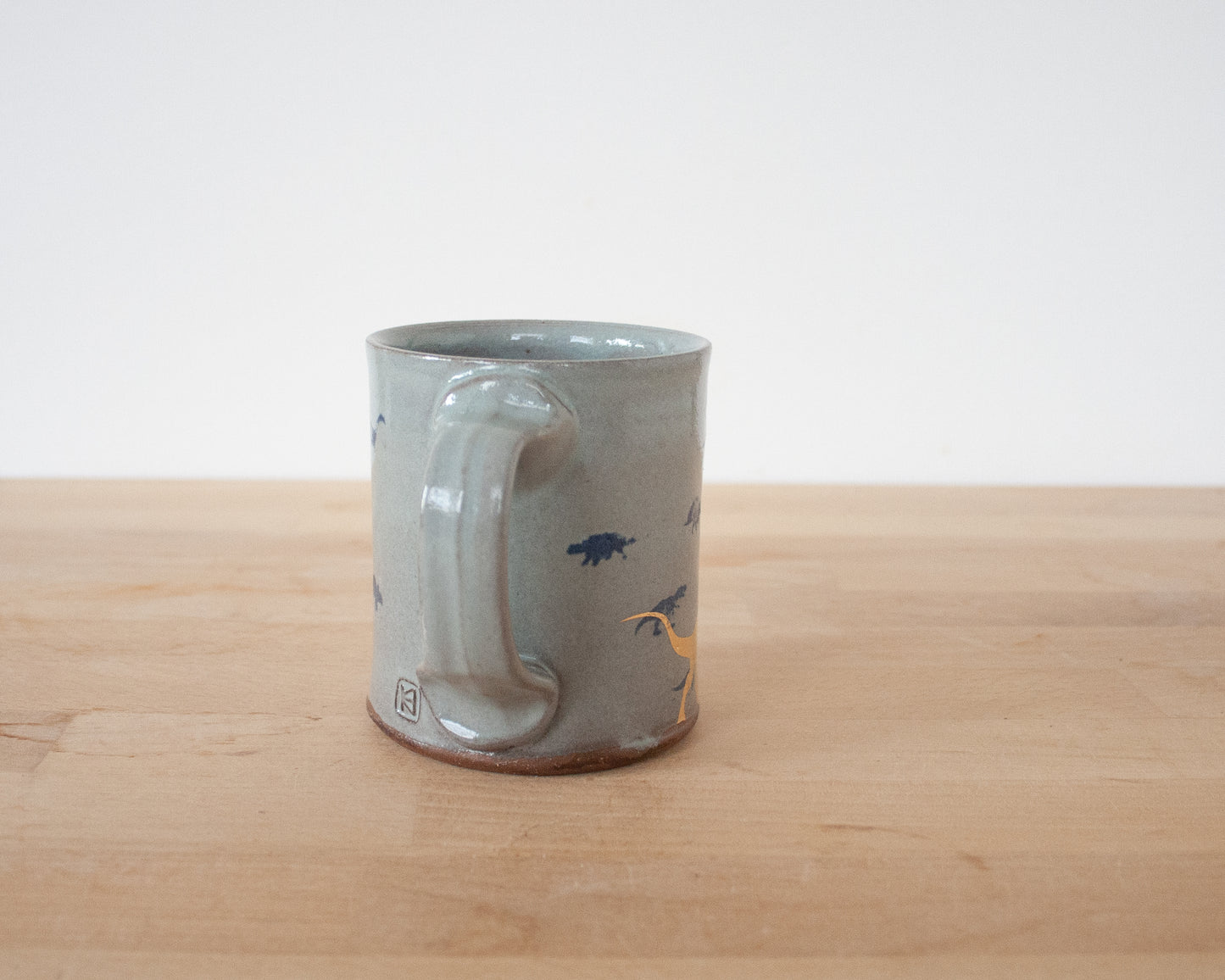 Gold Velociraptor Mug with small blue dinos