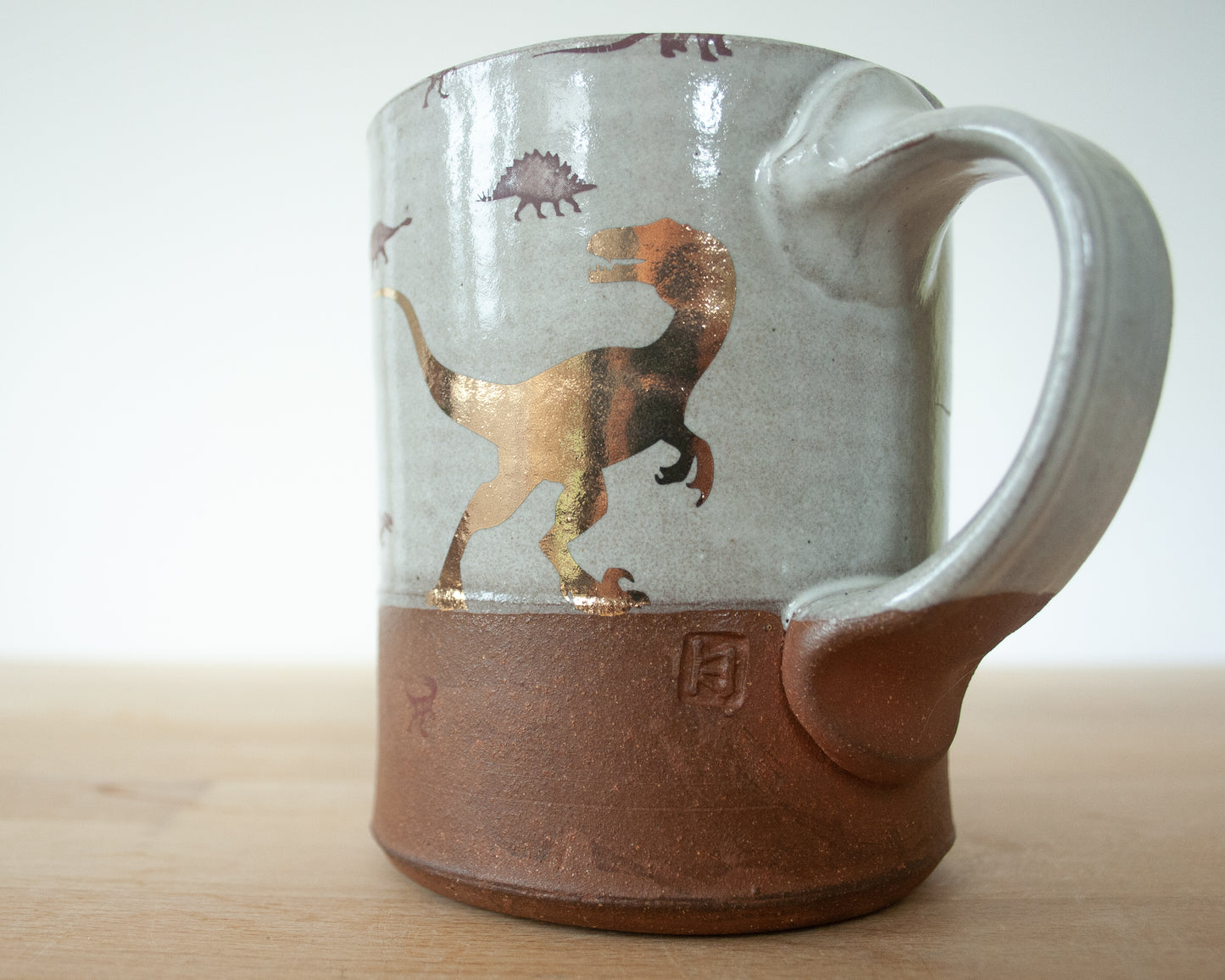 Gold Velociraptor mug with little dinosaurs
