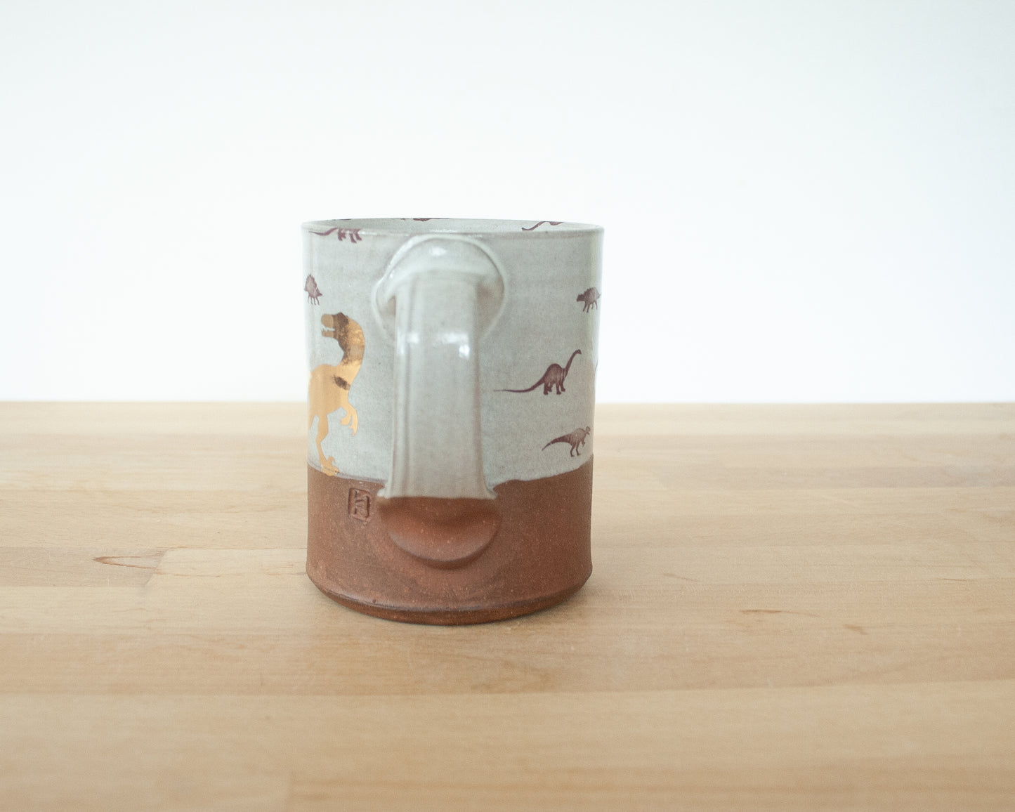 Gold Velociraptor mug with little dinosaurs