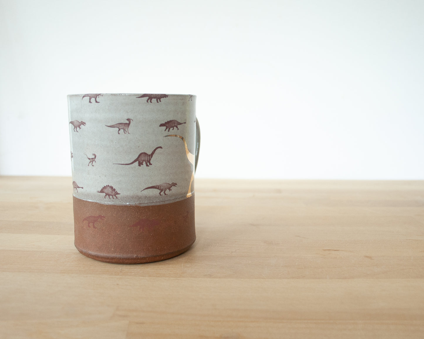 Gold Velociraptor mug with little dinosaurs
