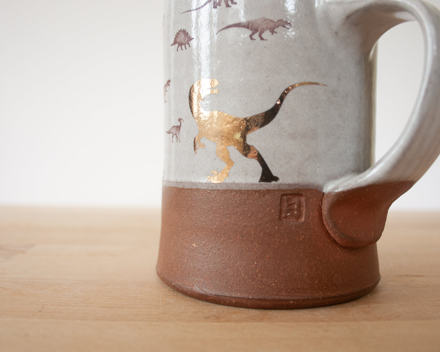 Gold Velociraptor mug with little dinosaurs