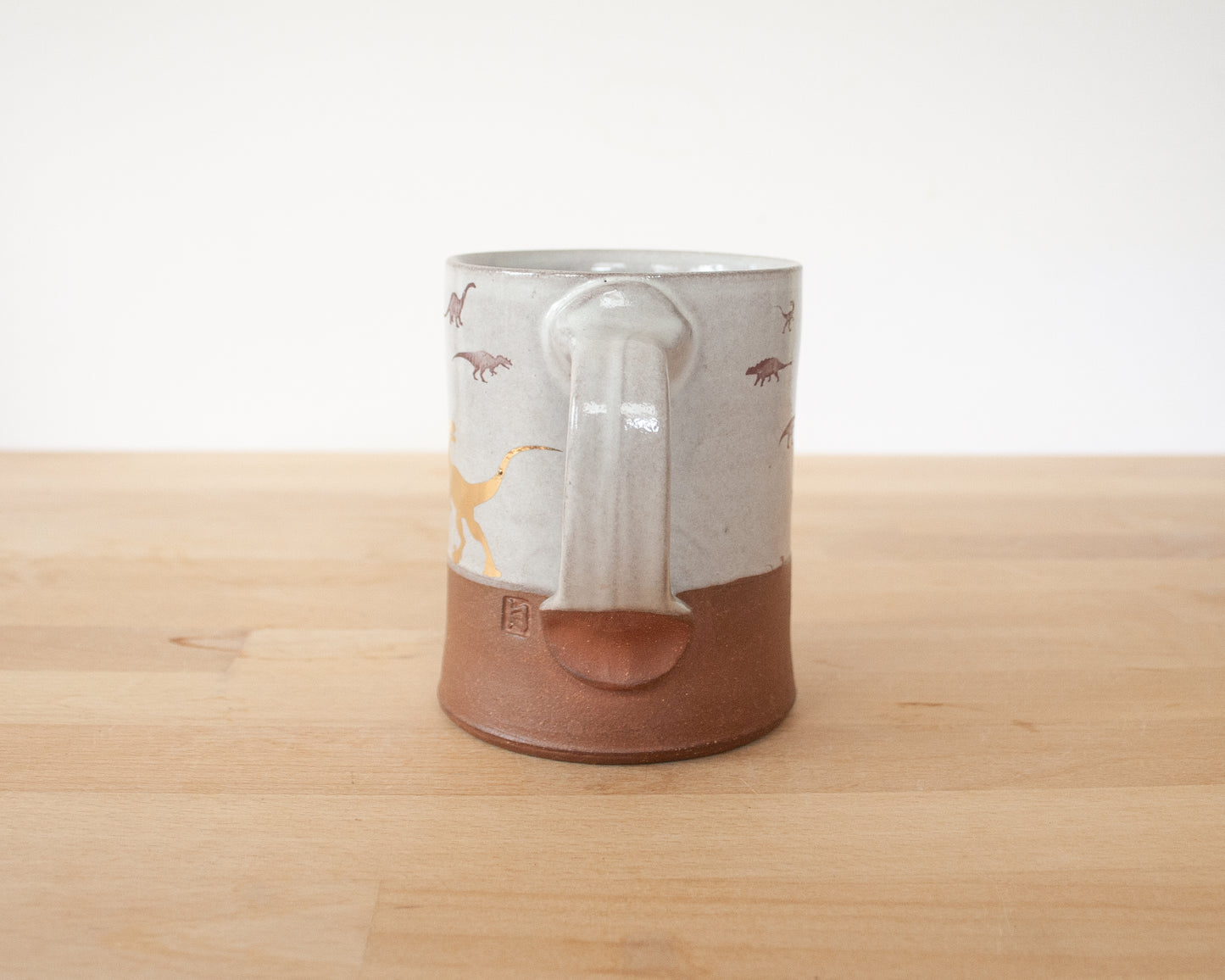 Gold Velociraptor mug with little dinosaurs