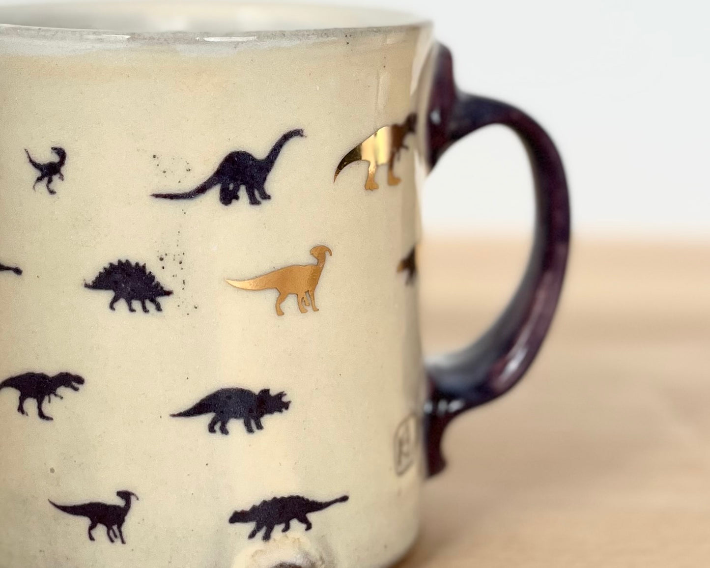 Mug with small purple and gold dinos