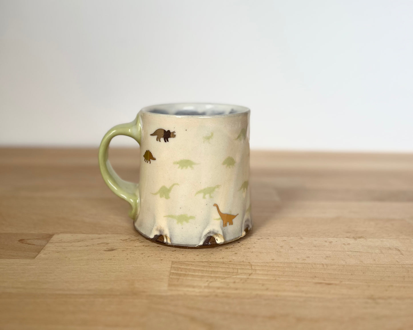 Mug with small green and gold dinos