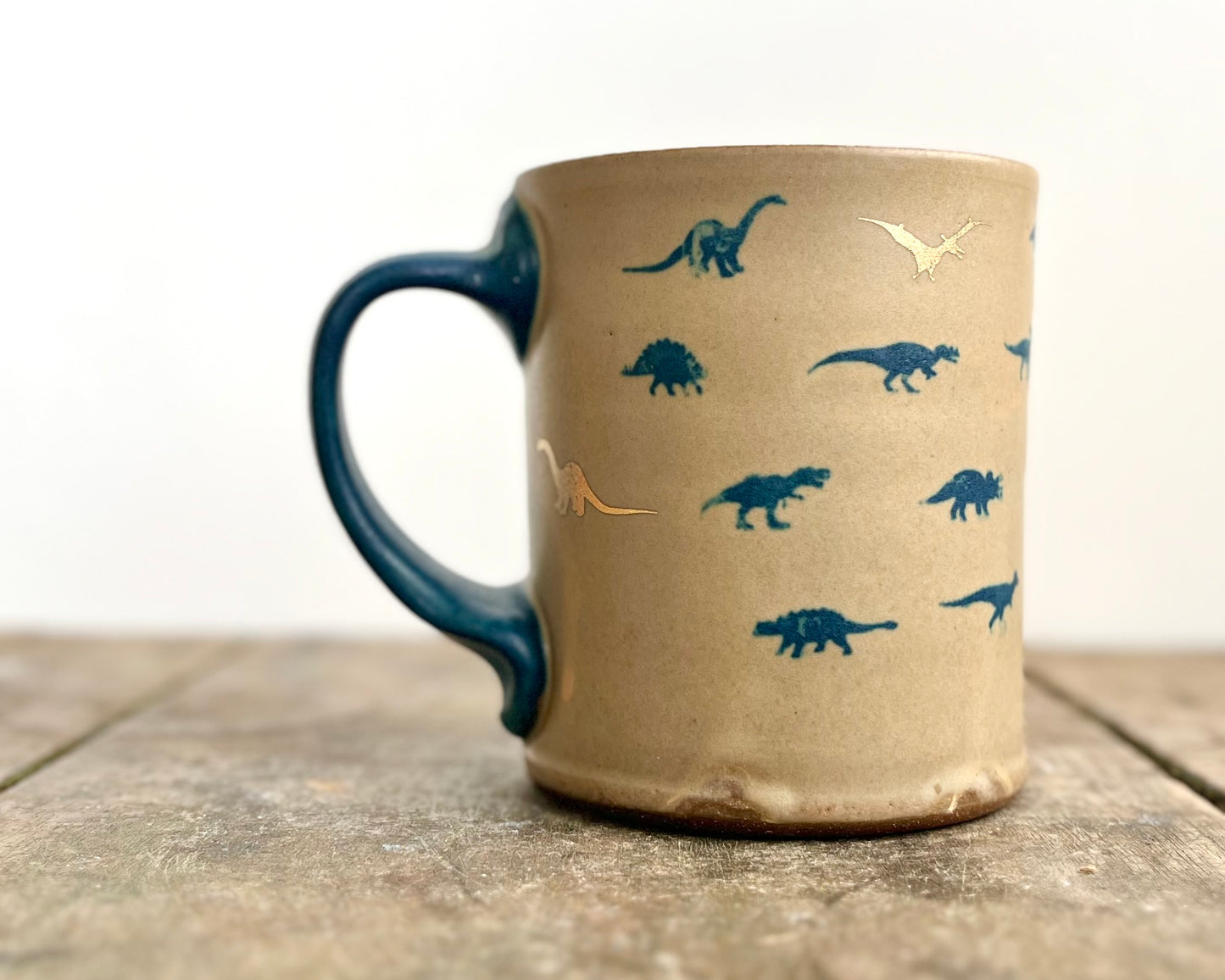 Mug with matte glaze and small blue and gold dinos
