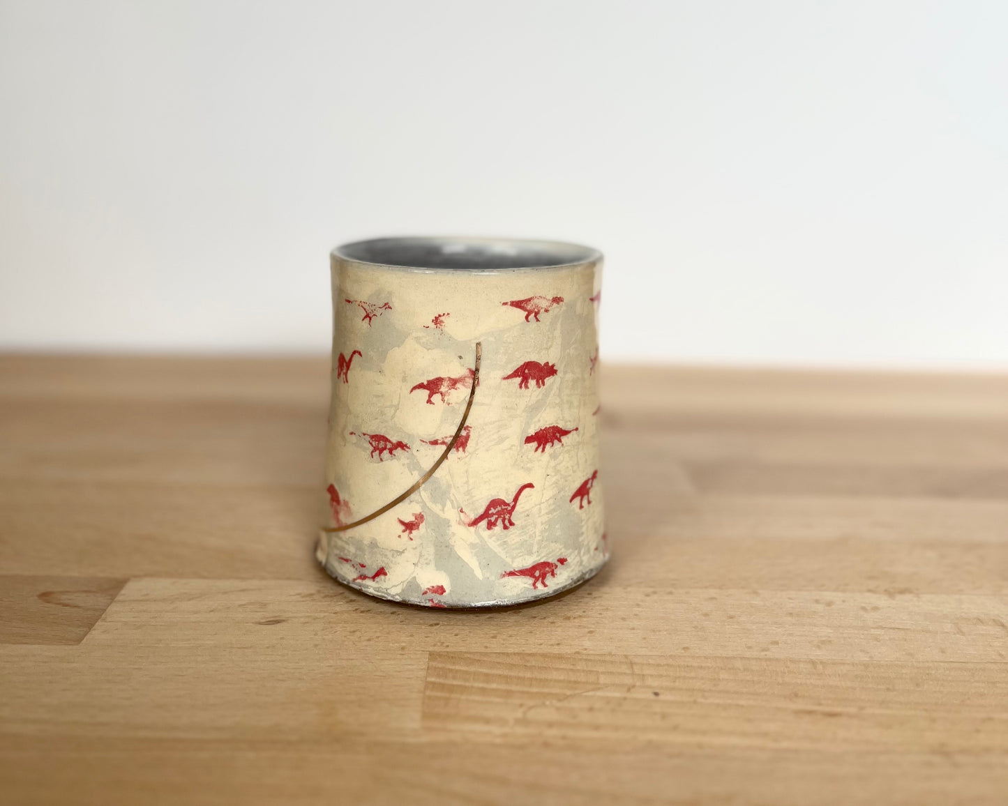 Mug with small red and gold dinos with Fibonacci spiral