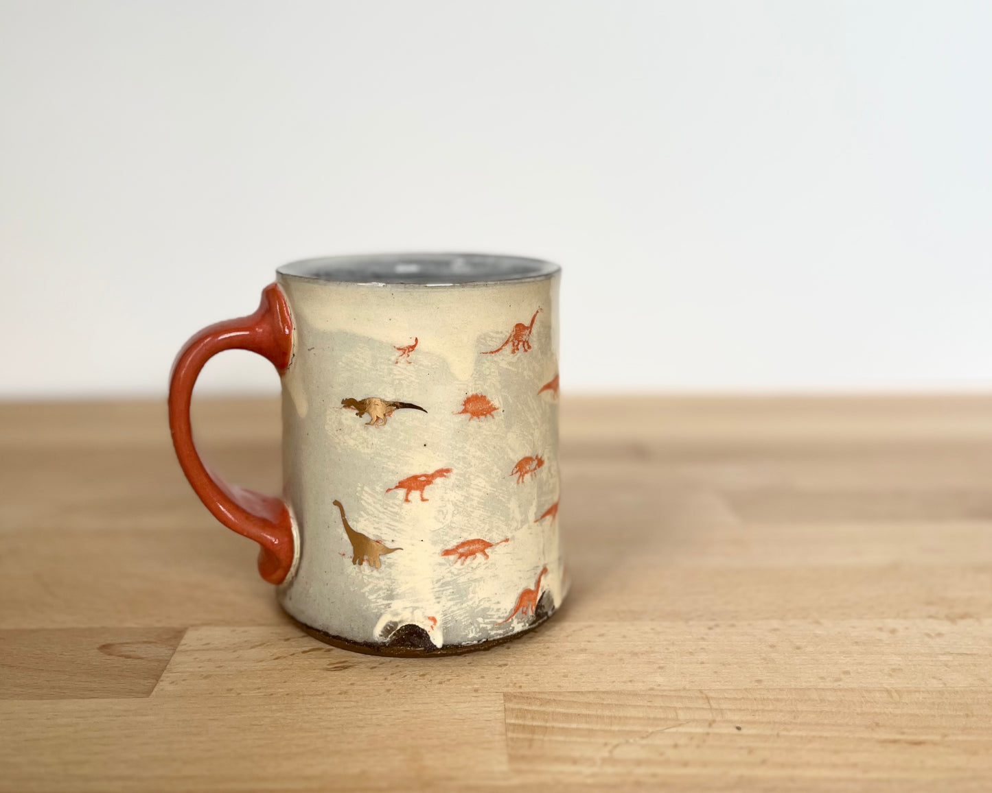 Mug with small orange and gold dinos