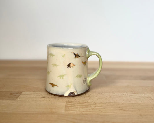 Mug with small green and gold dinos