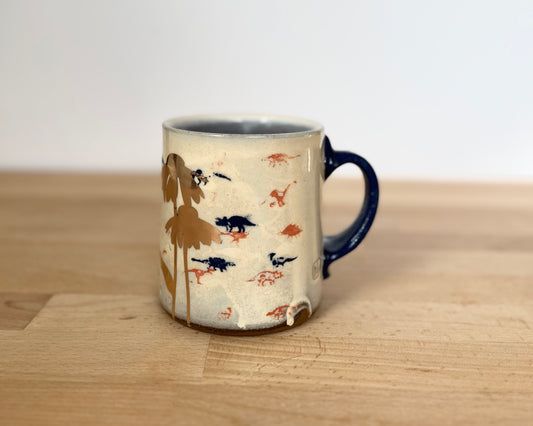 Mug with small orange, blue and gold dinos