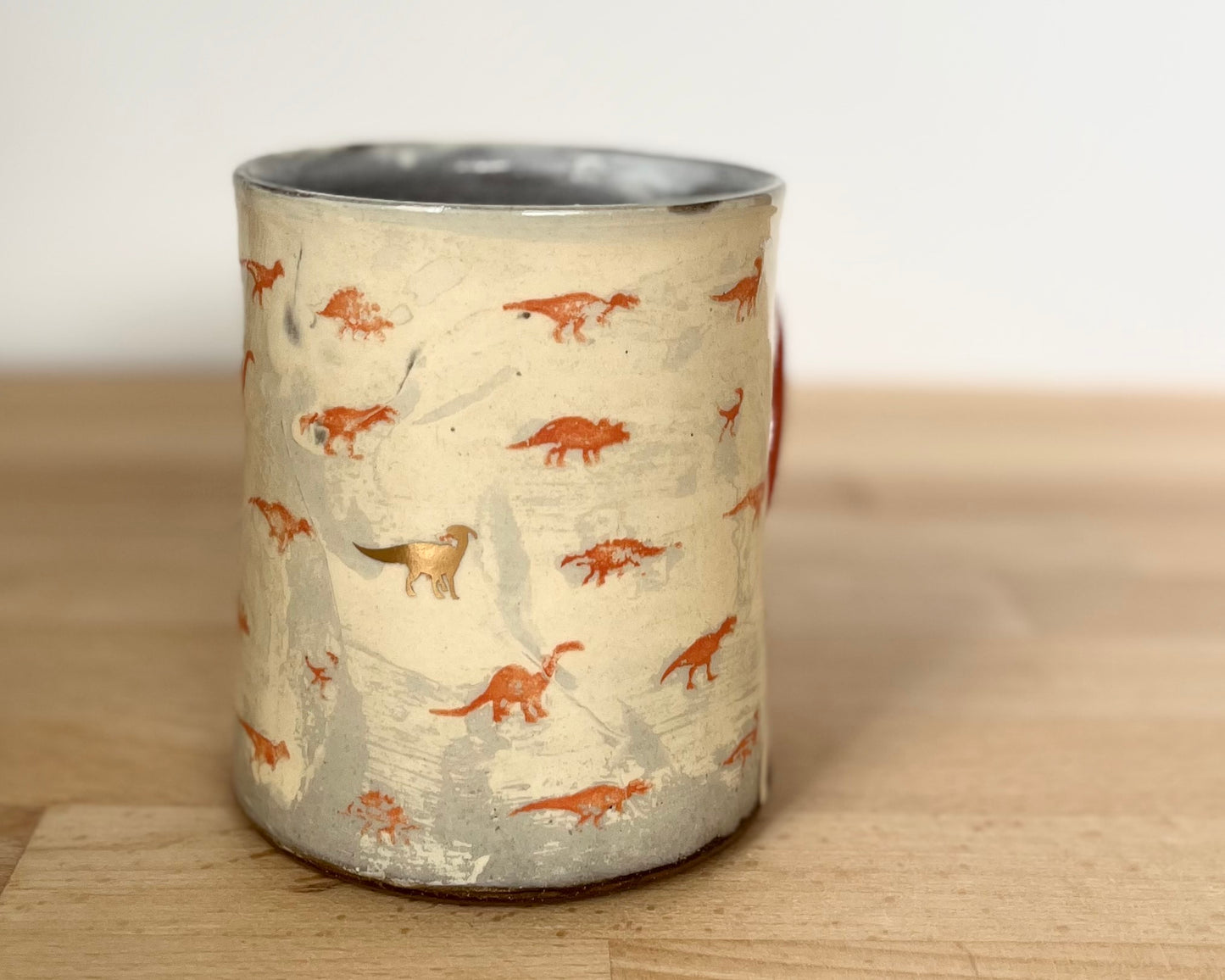 Mug with small orange and gold dinos