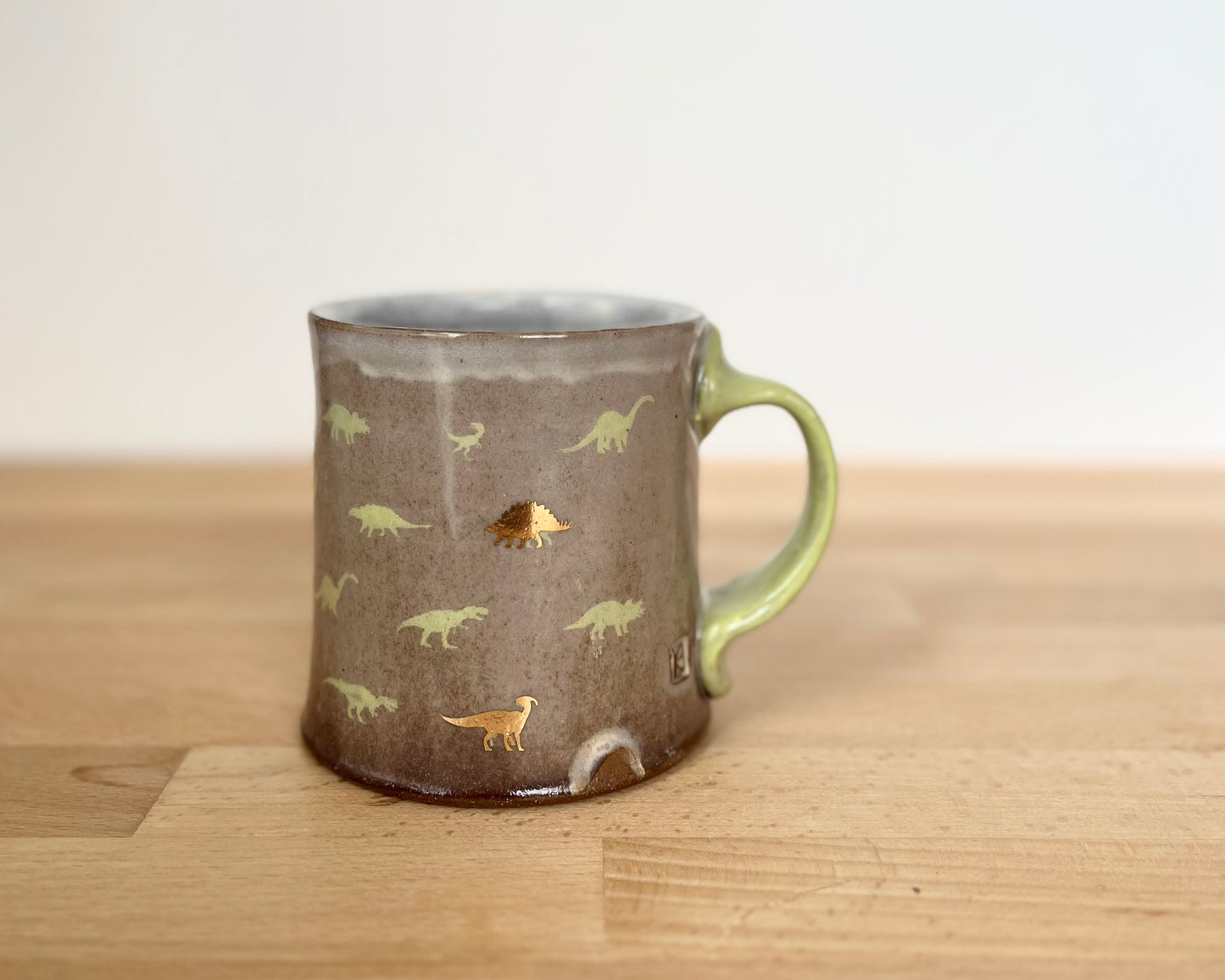 Mug with small green and gold dinos