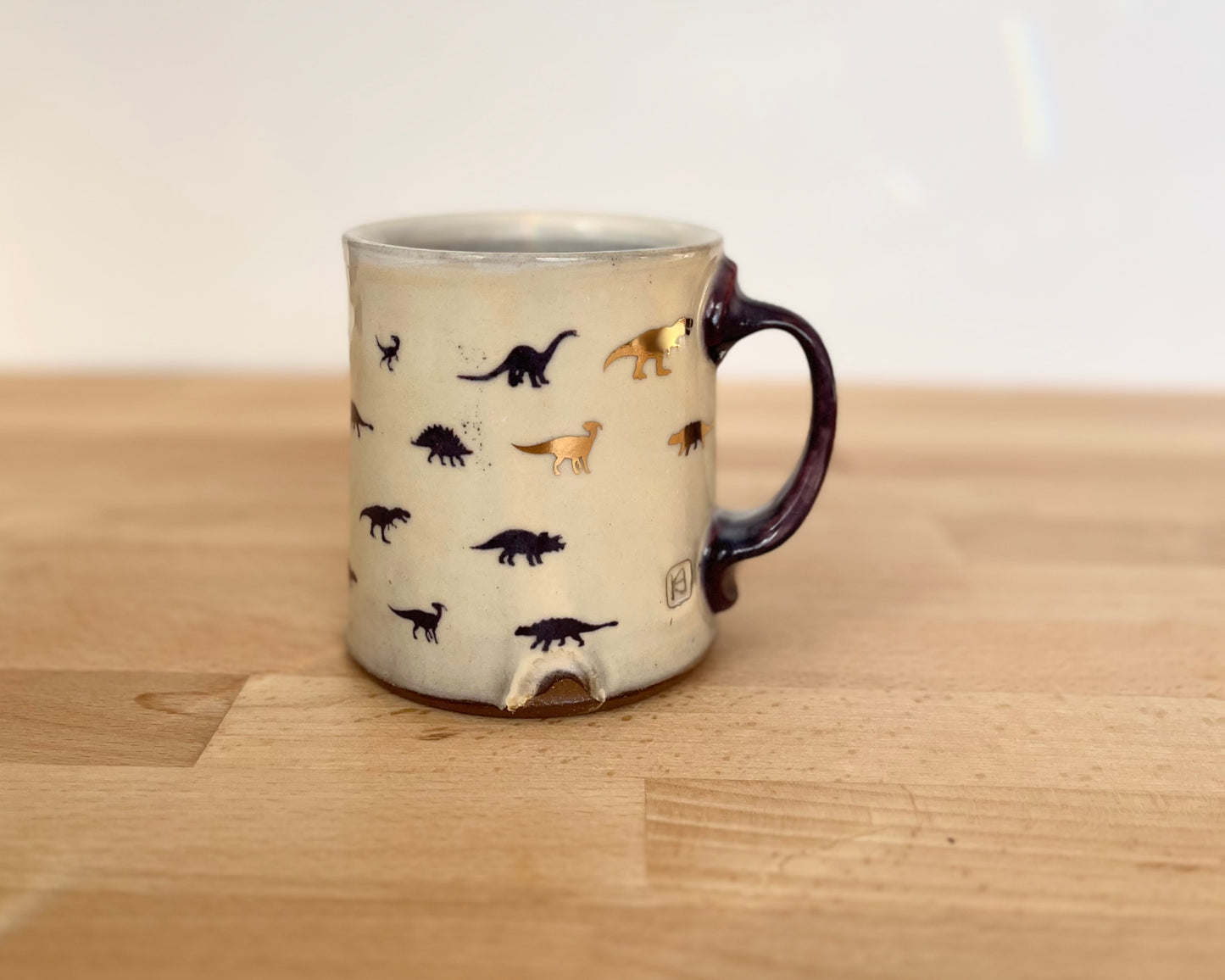 Mug with small purple and gold dinos