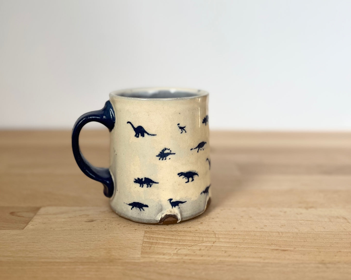 Mug with small orange, blue and gold dinos