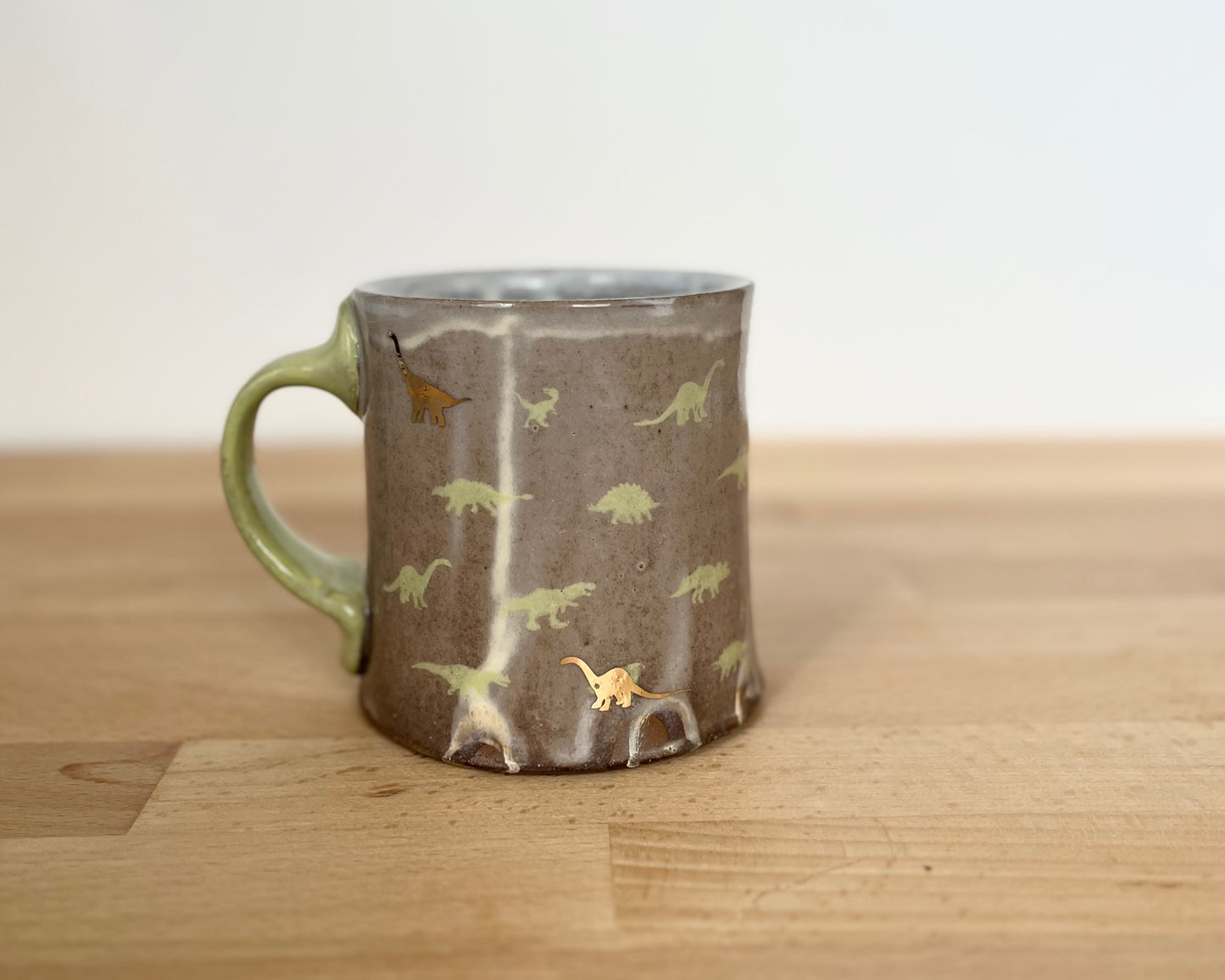 Mug with small green and gold dinos