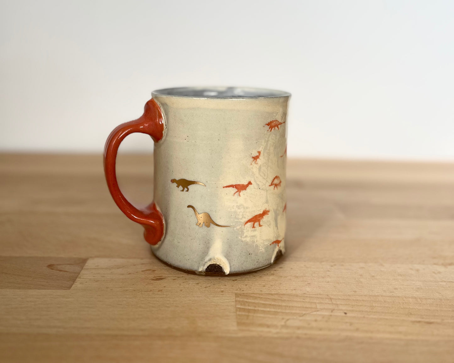 Mug with small orange and gold dinos