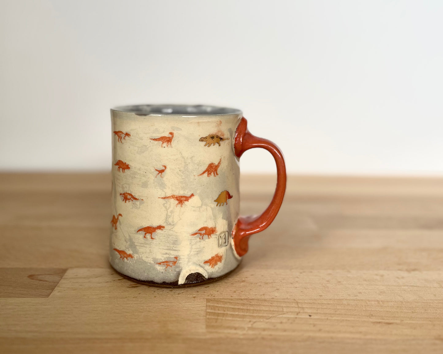 Mug with small orange and gold dinos