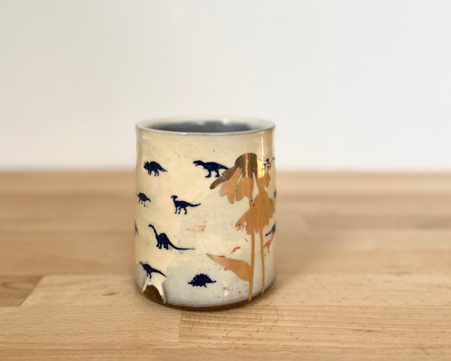 Mug with small orange, blue and gold dinos