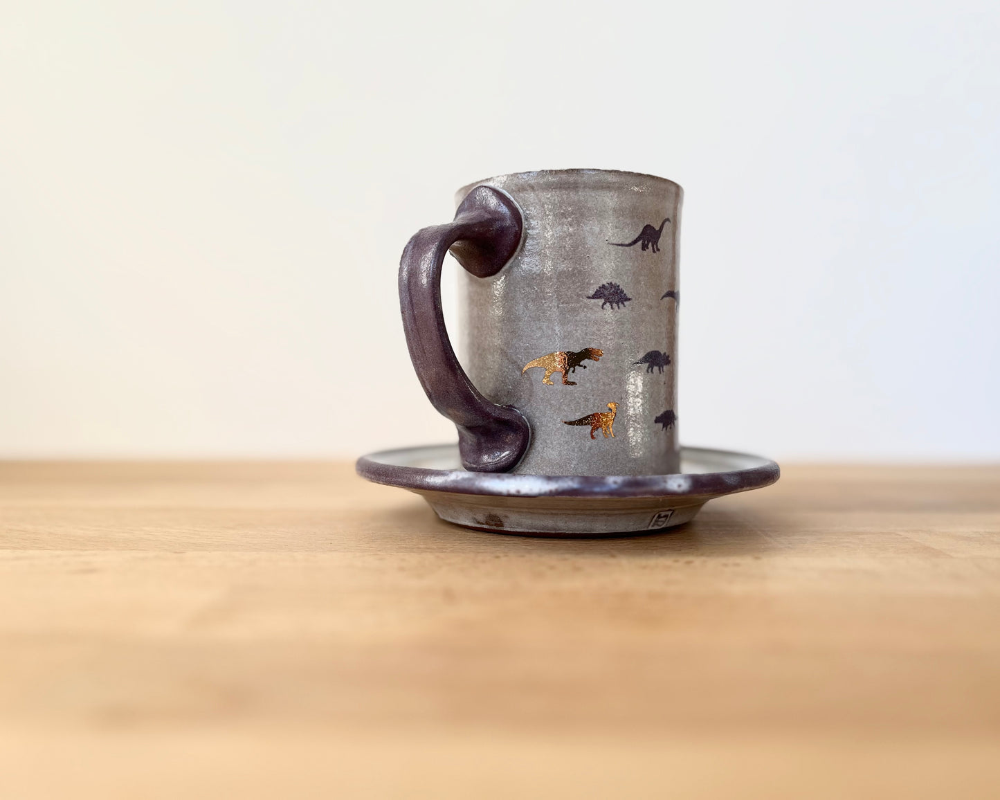 Mug and Saucer with purple and gold dinosaurs