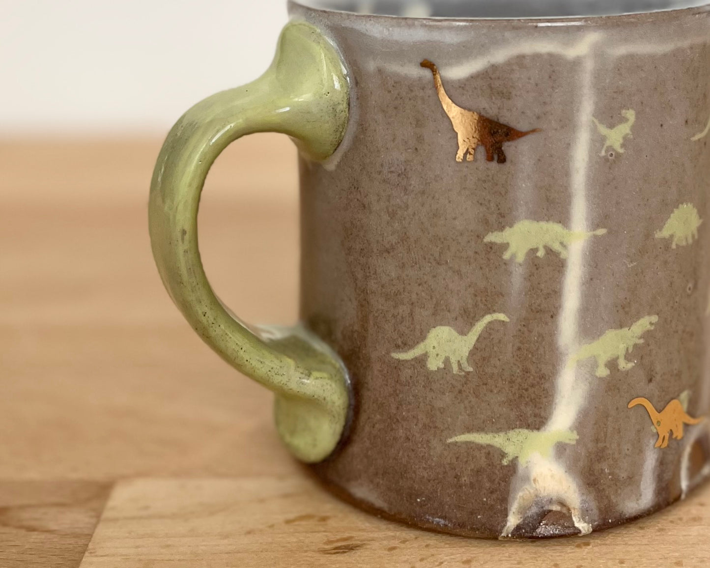 Mug with small green and gold dinos