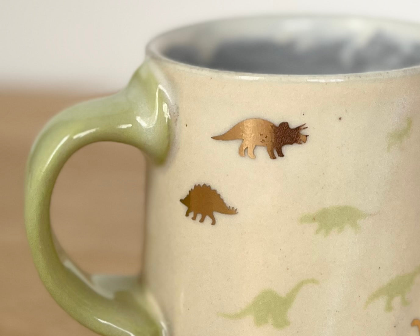 Mug with small green and gold dinos