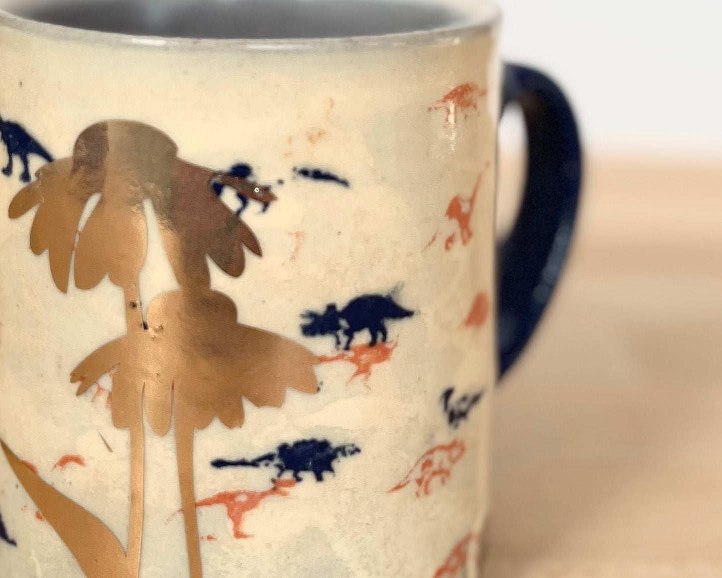 Mug with small orange, blue and gold dinos