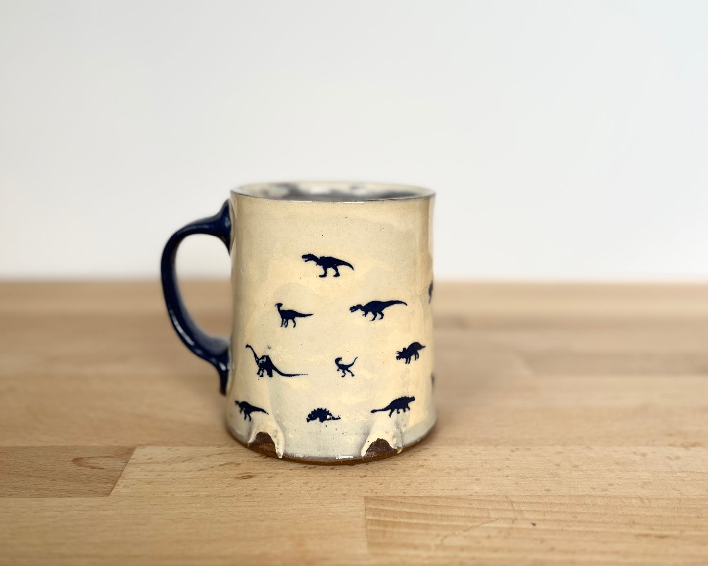 Mug with small orange, blue and gold dinos