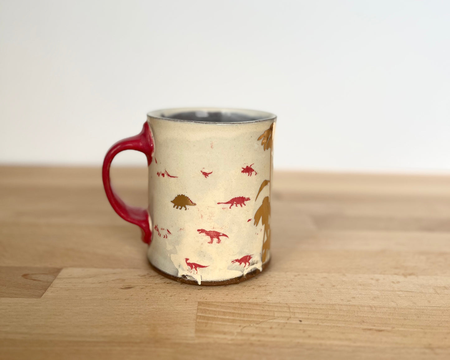 Mug with small red and gold dinos