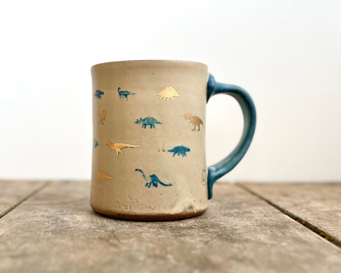 Mug with matte glaze and small blue and gold dinos