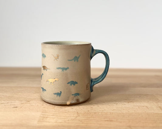 Mug with matte glaze and small blue and gold dinos