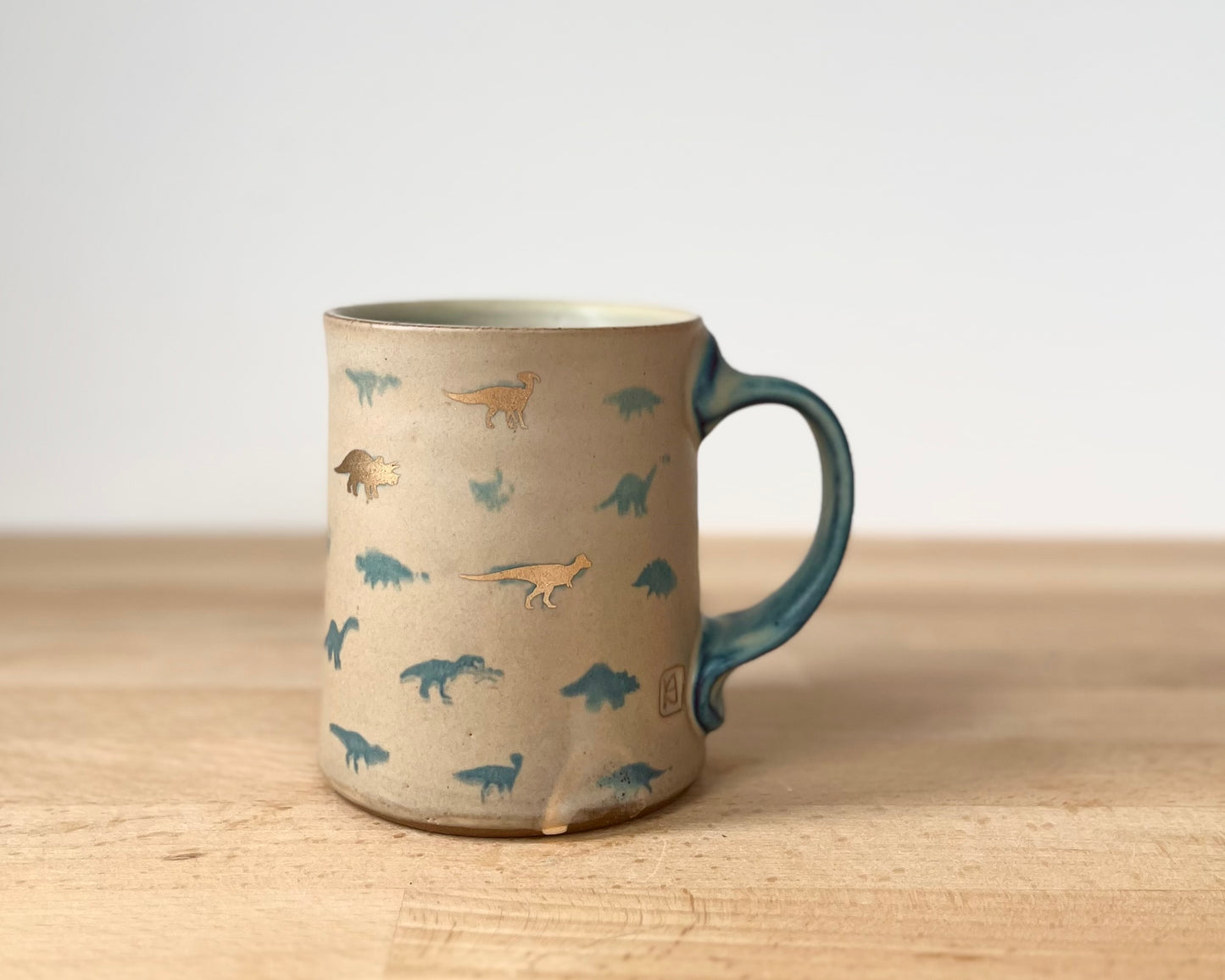 Mug with matte glaze and small blue and gold dinos