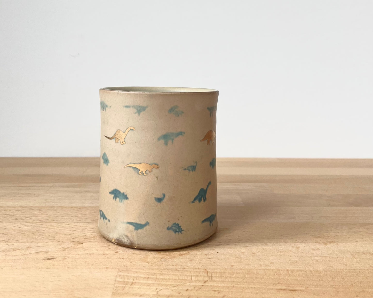 Mug with matte glaze and small blue and gold dinos