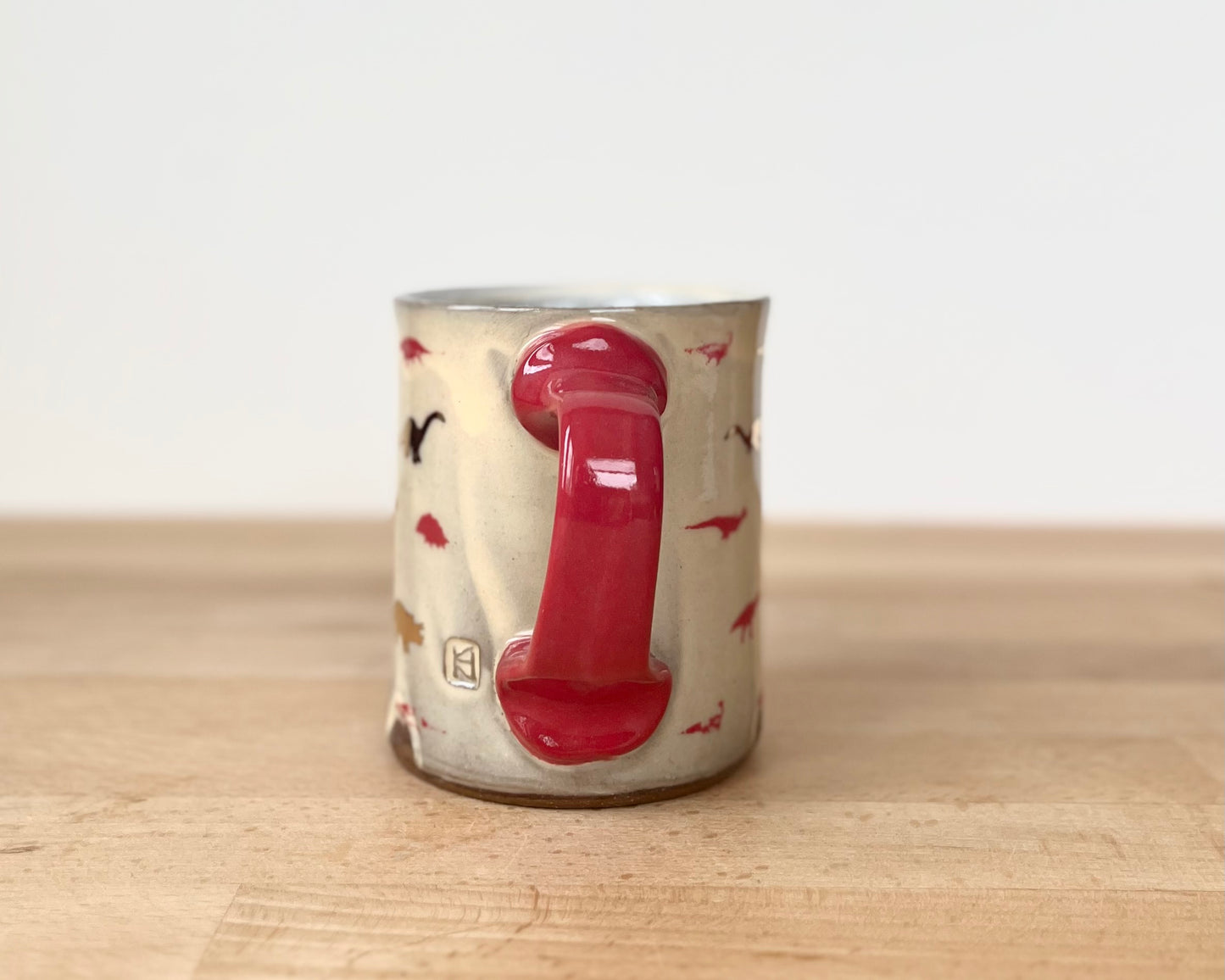 Mug with small red and gold dinos