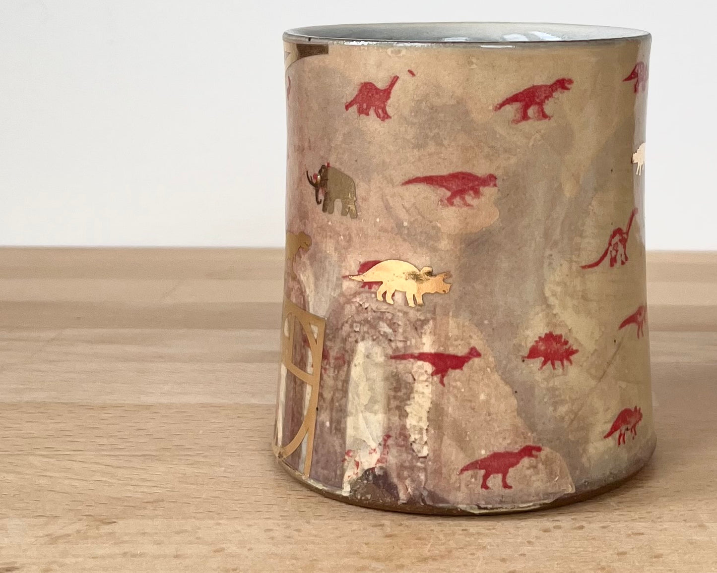 Mug with small red and gold dinos with fibonacci spiral