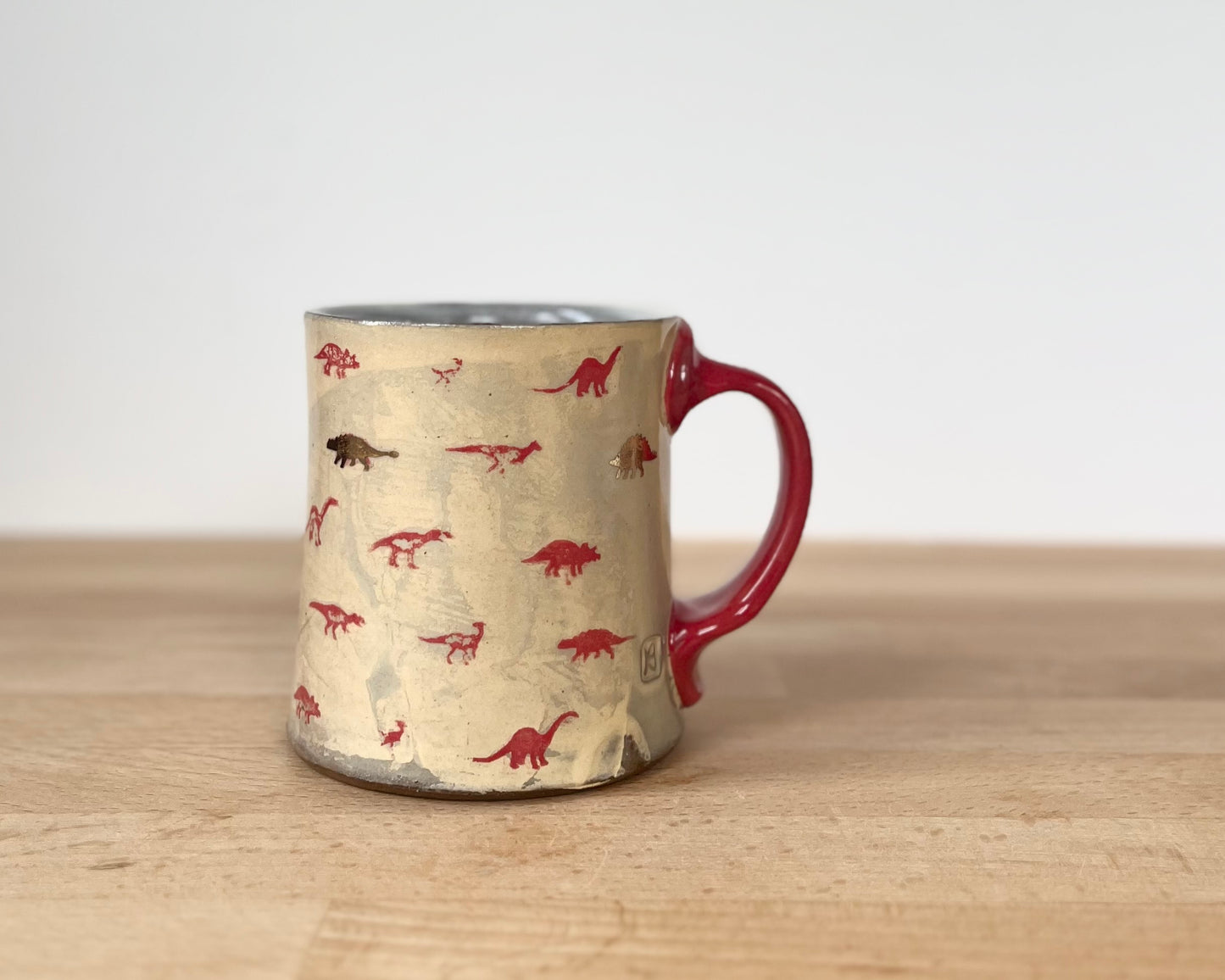 Mug with small red and gold dinos with fibonacci spiral