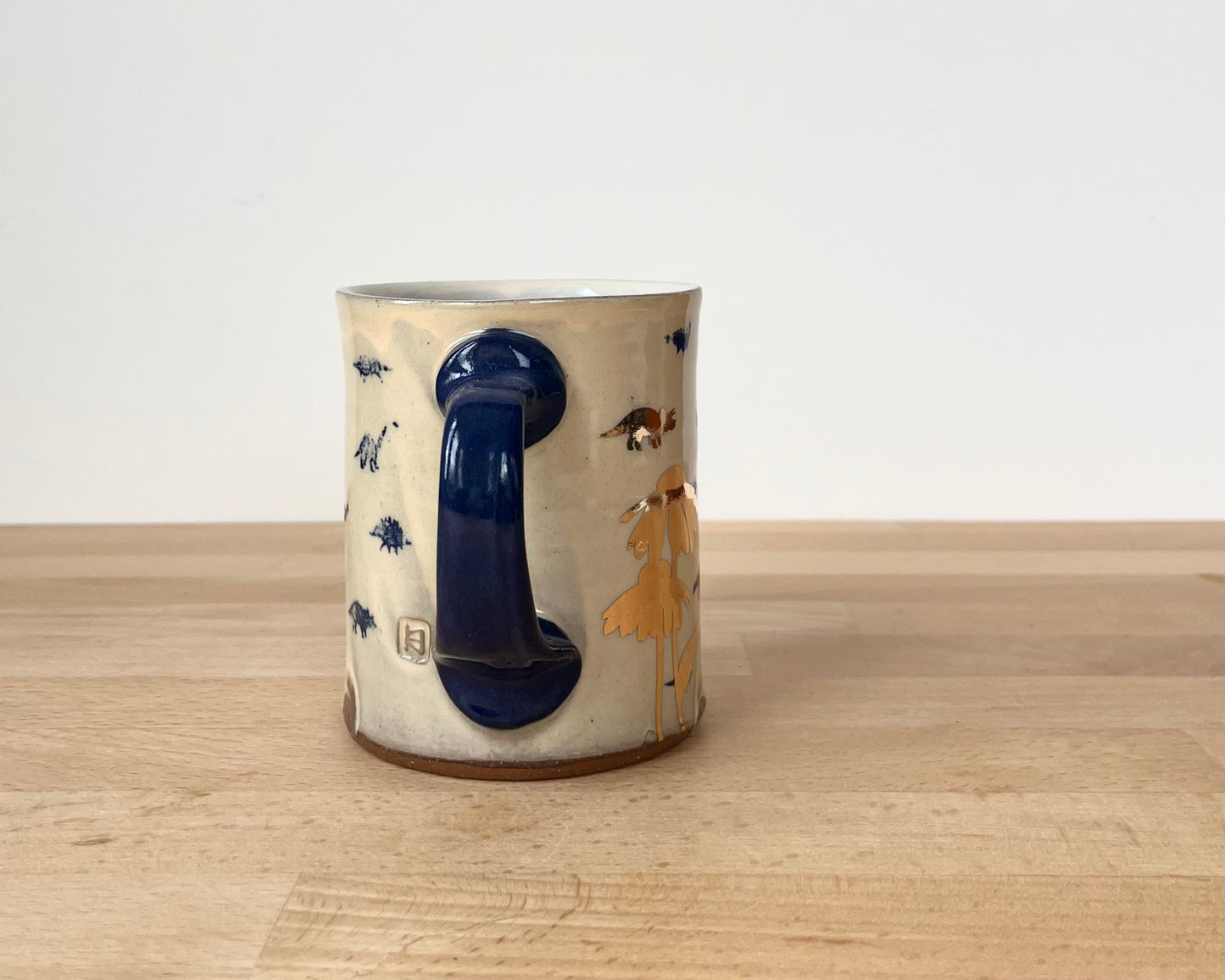 Mug with small blue and gold dinos and coneflower