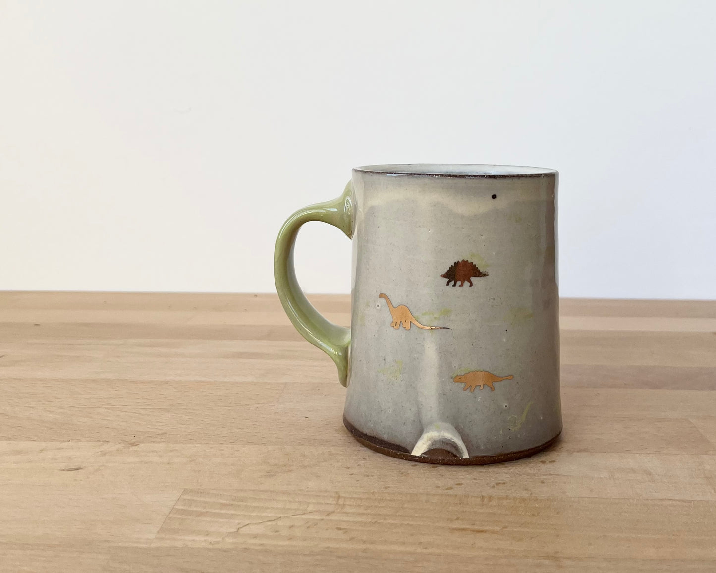 Mug with small light green and gold dinos