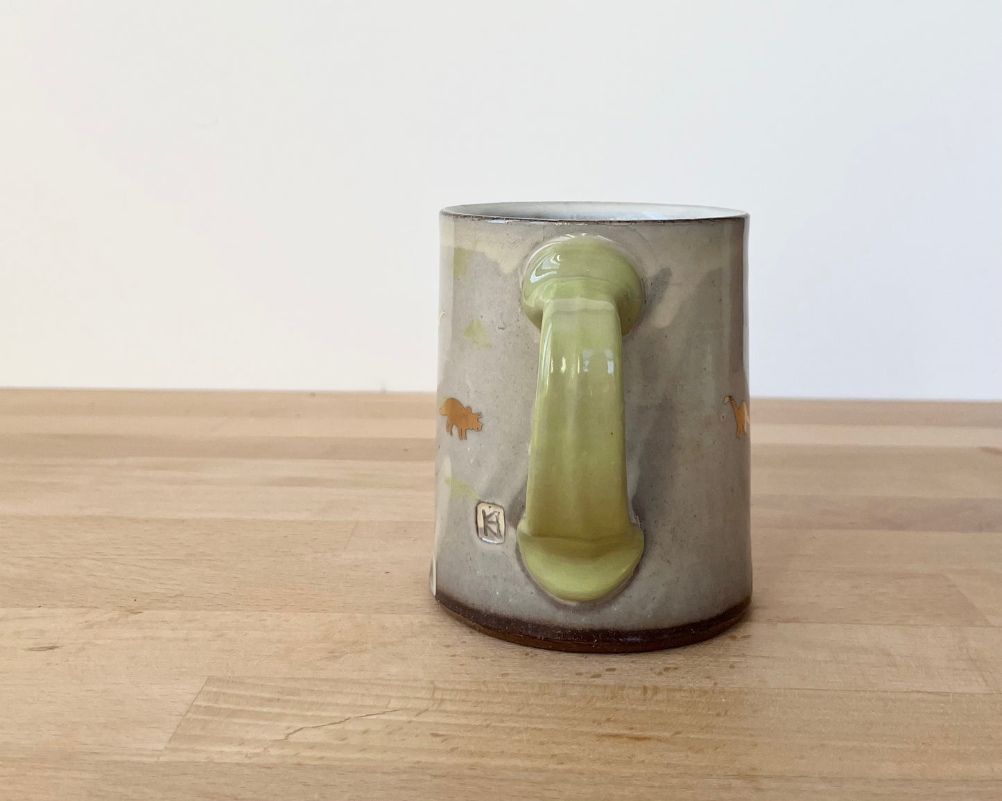 Mug with small light green and gold dinos