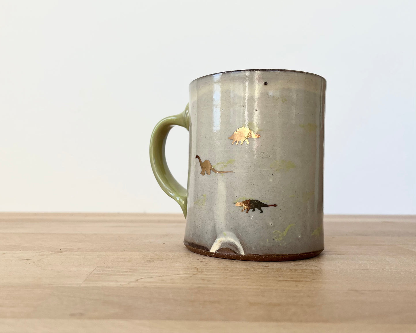 Mug with small light green and gold dinos