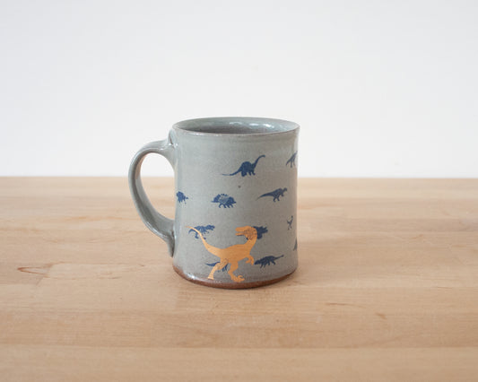 Gold Velociraptor Mug with small blue dinos